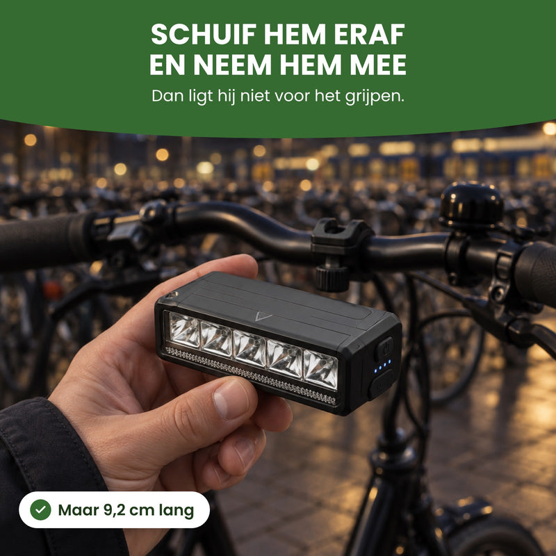 Voltura-Fahrradlampe in der Hand neben dem abgestellten Fahrrad: abschieben und mitnehmen, nur 9,2 cm lang